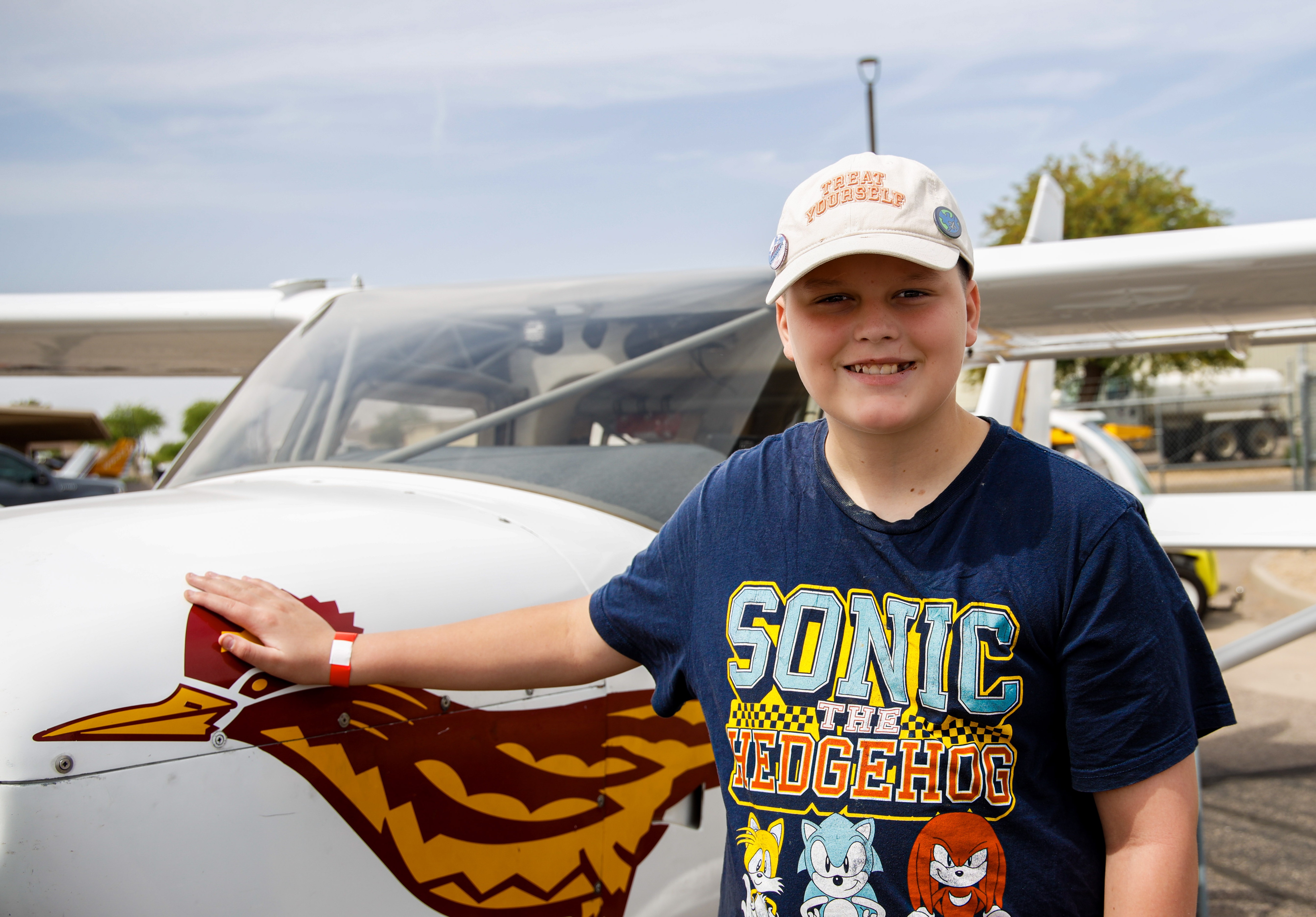 Blake standing next to white plane with roadrunner on it.