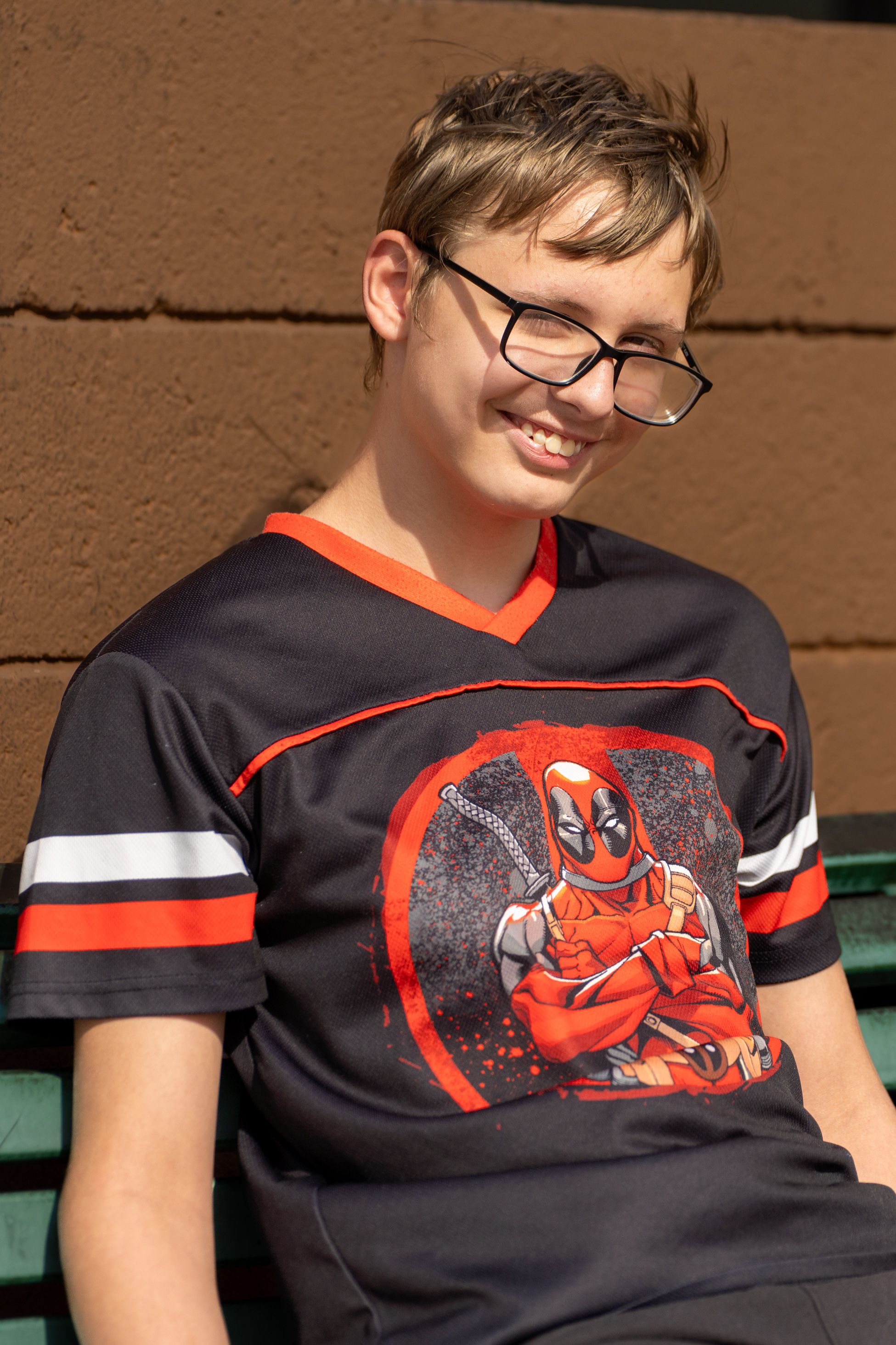 Kolby standing smiling brown background