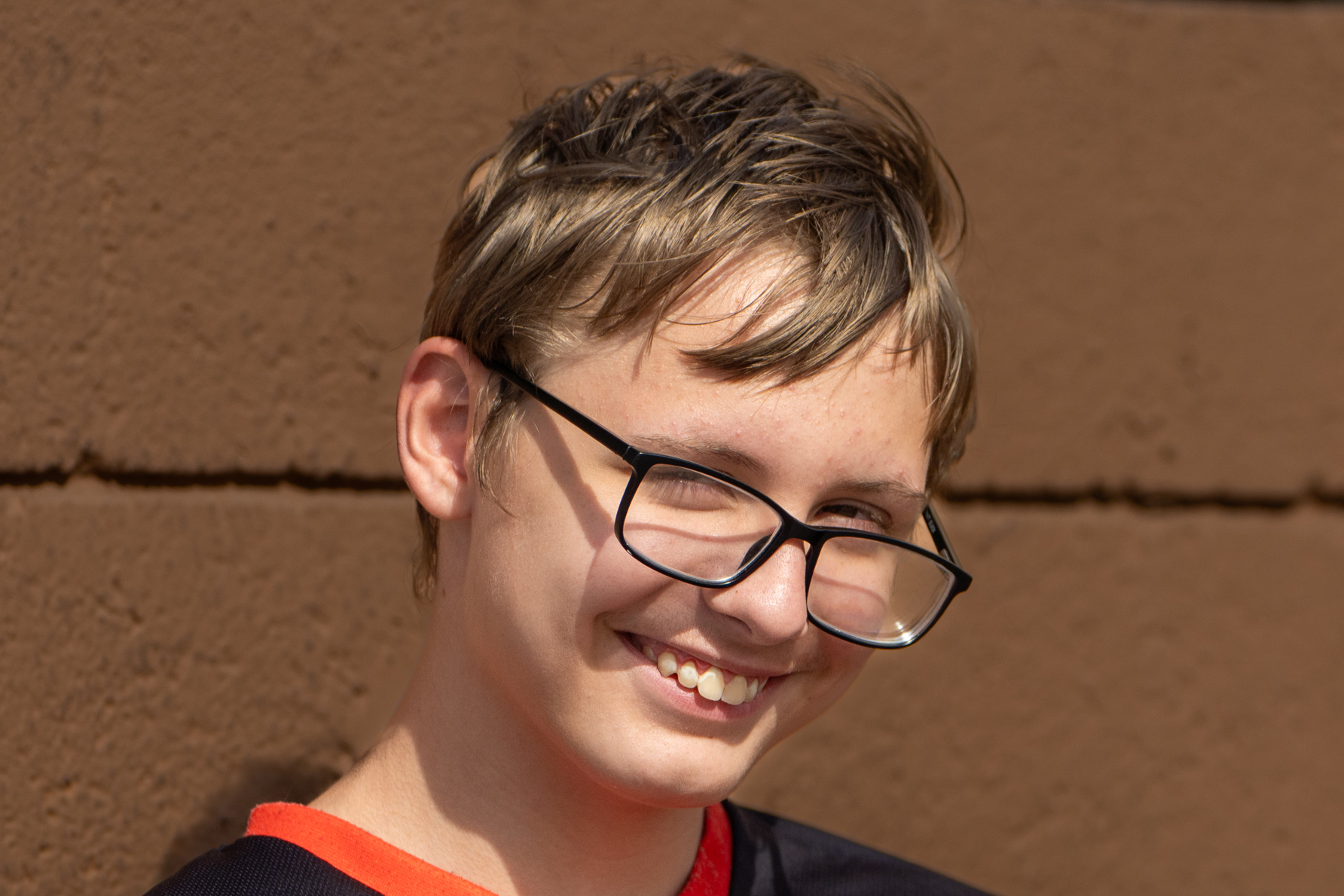 Kolby smiling brown background