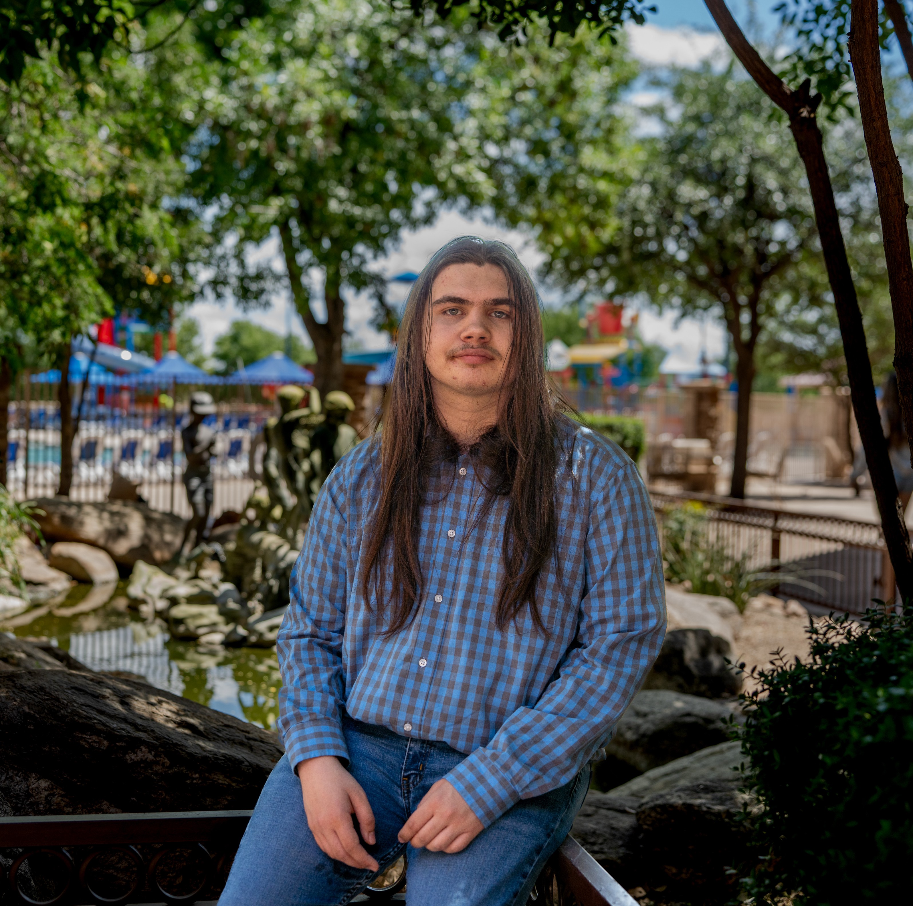 Ivanking sitting with pool and trees in background