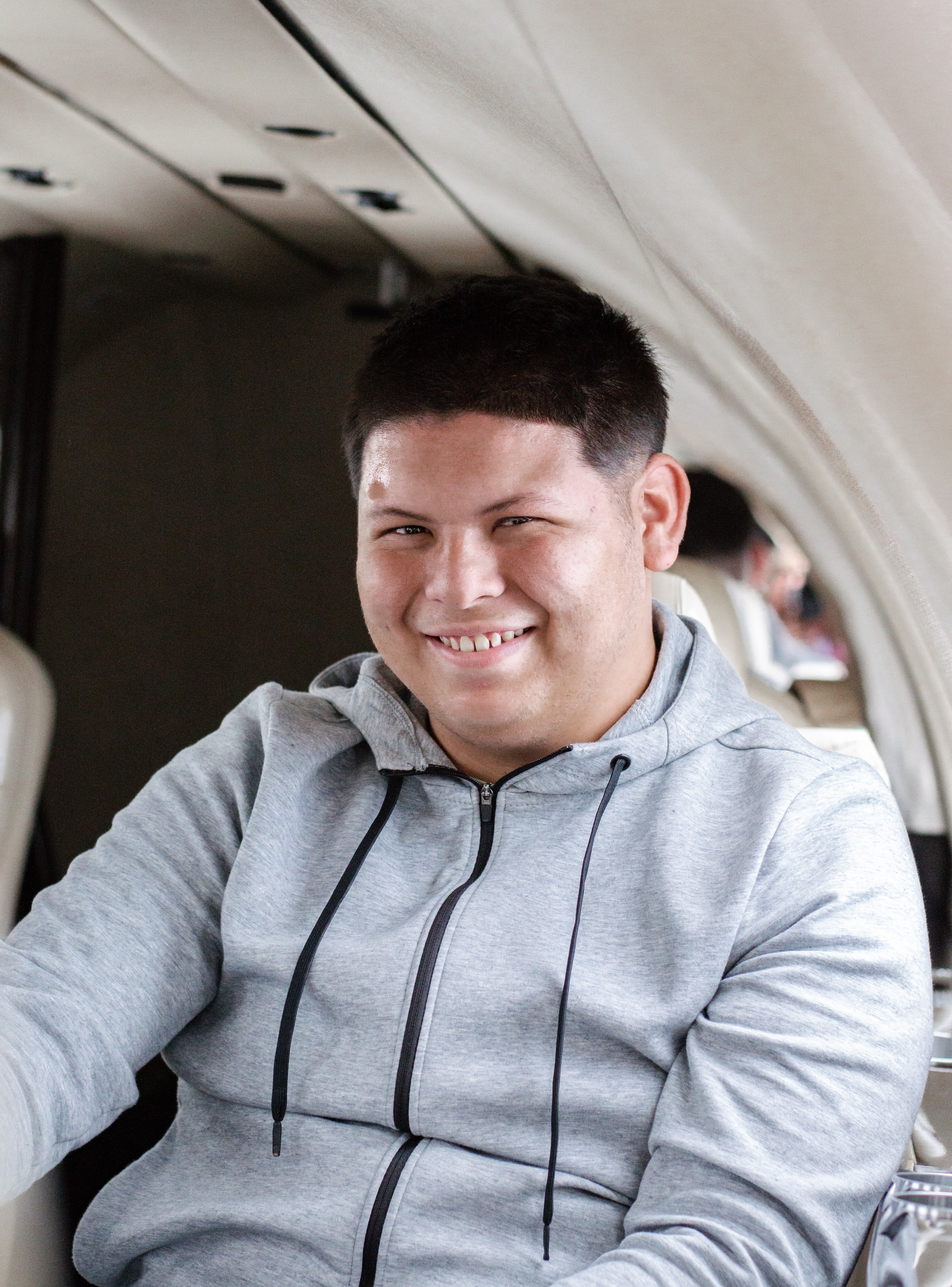 Joshua (2) sitting in plane smiling