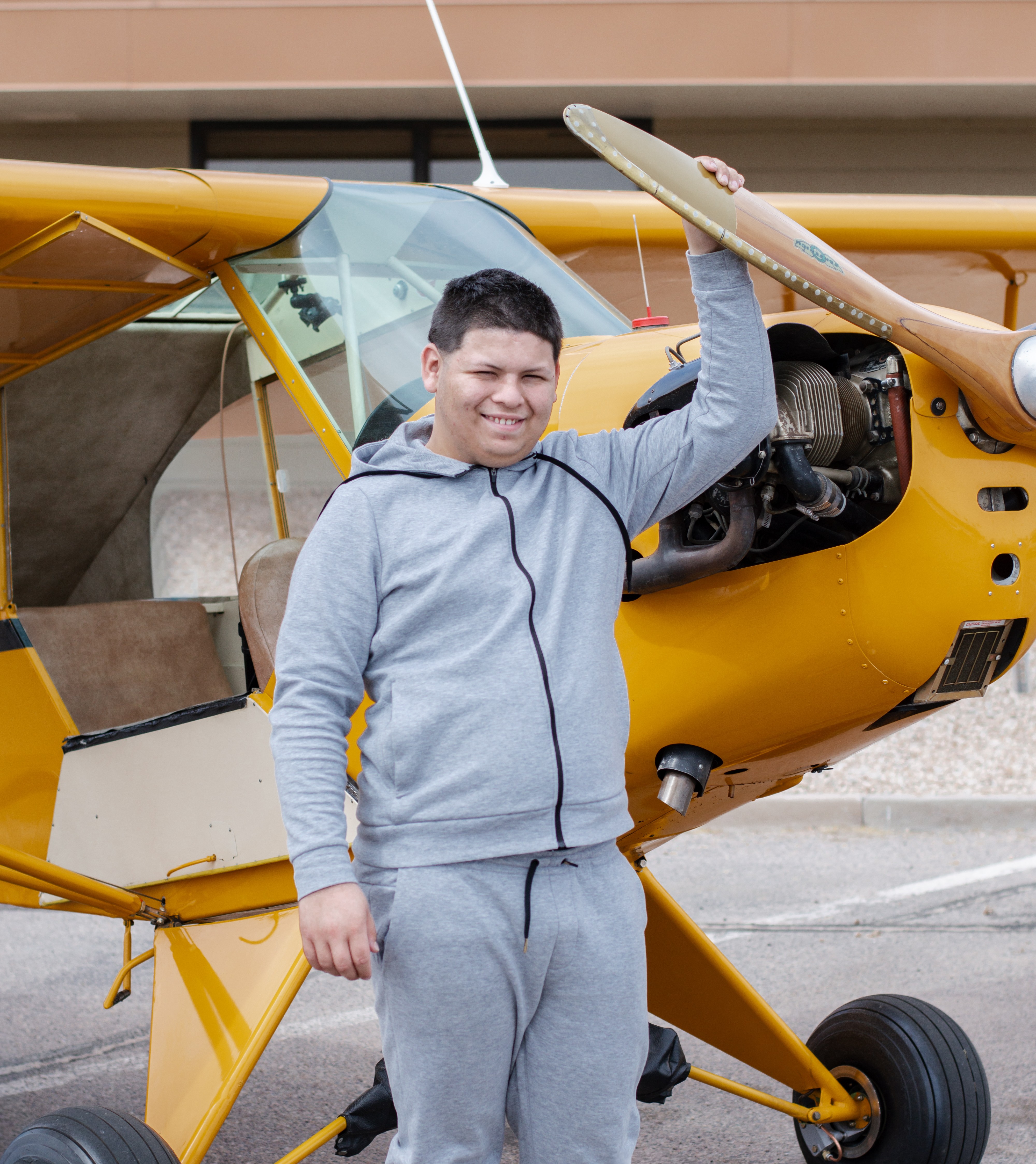 Joshua (2) standing in front of yellow plane
