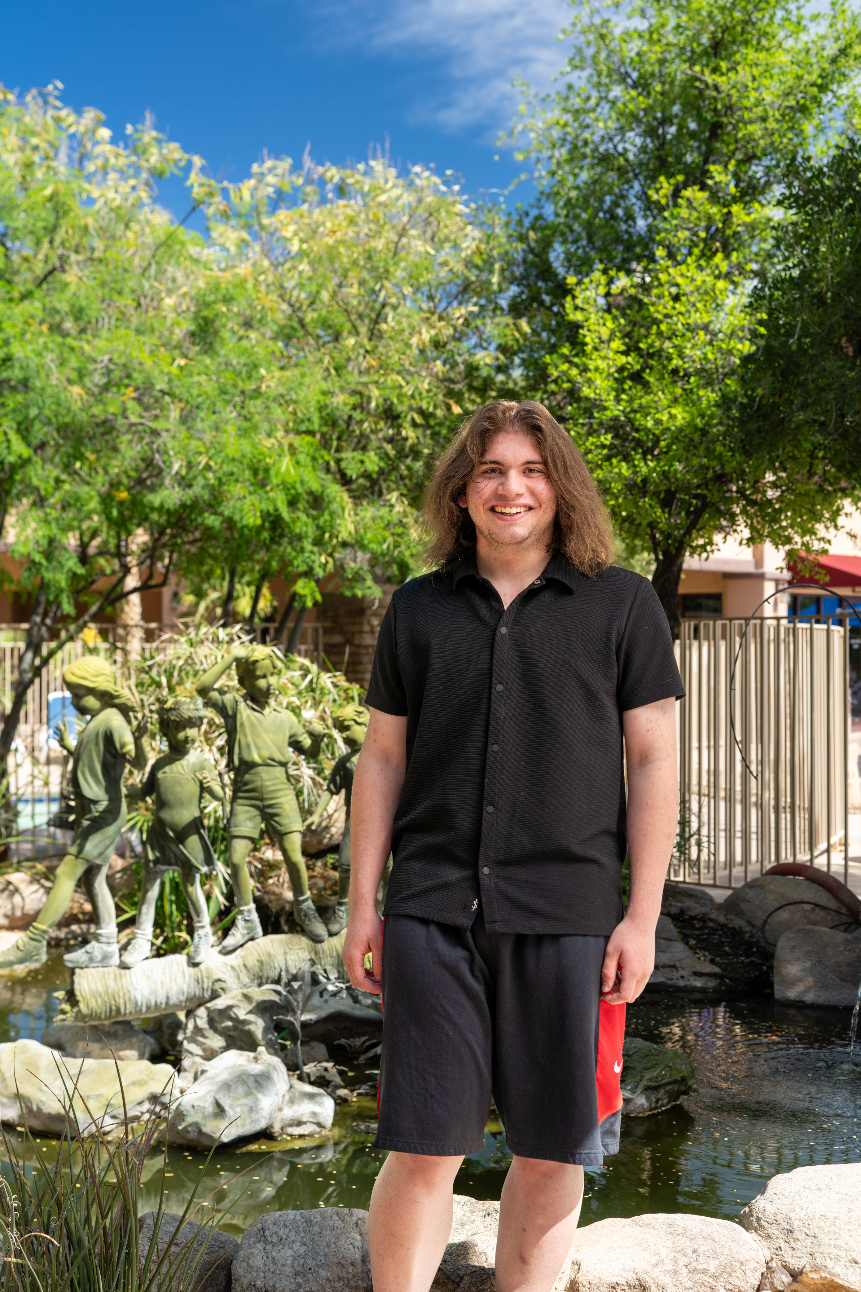 Nathan standing by water and trees