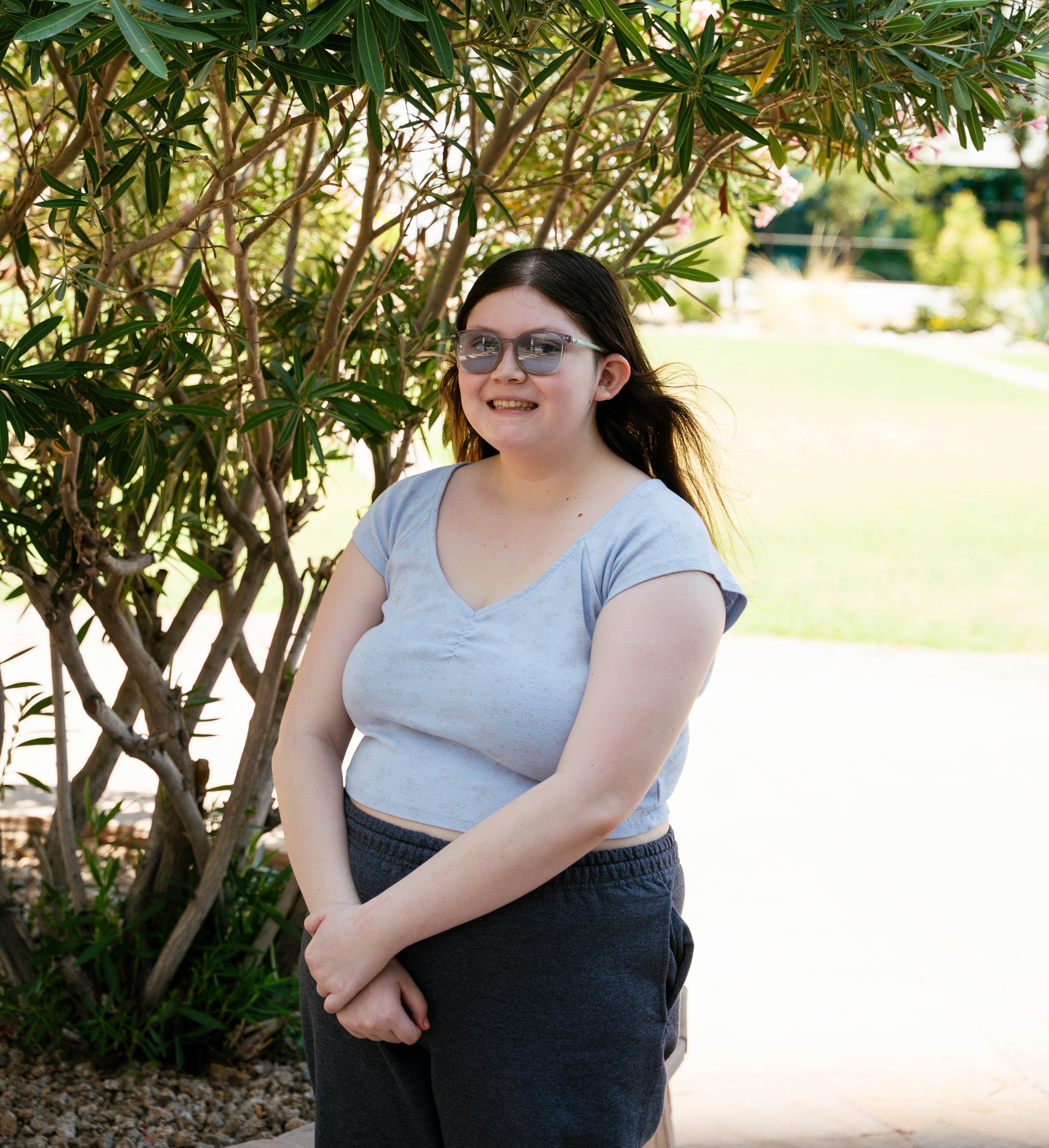 Valerie (2) standing with glasses on by tree
