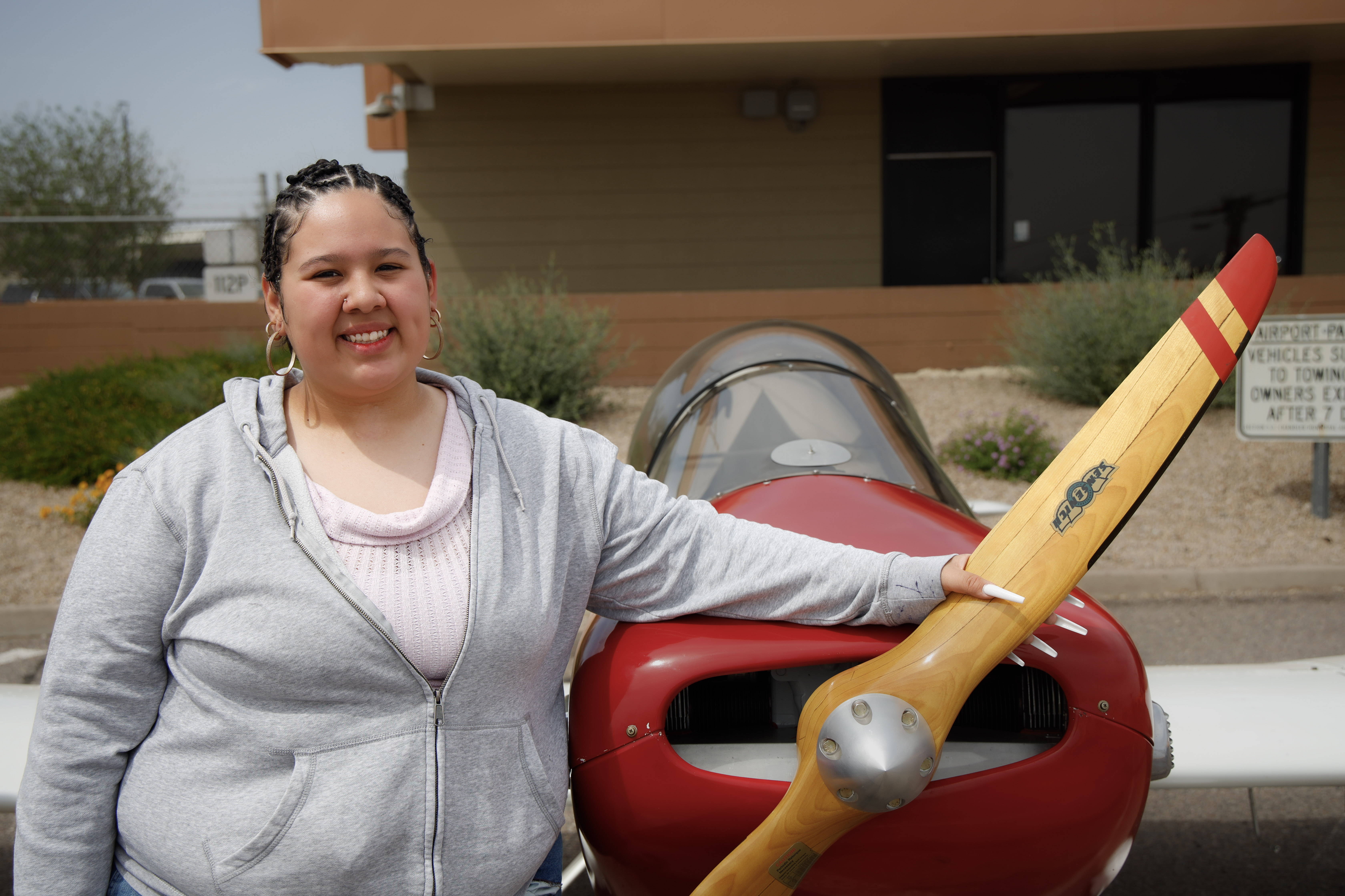 Adriana (Paulina) standing in front of red plane