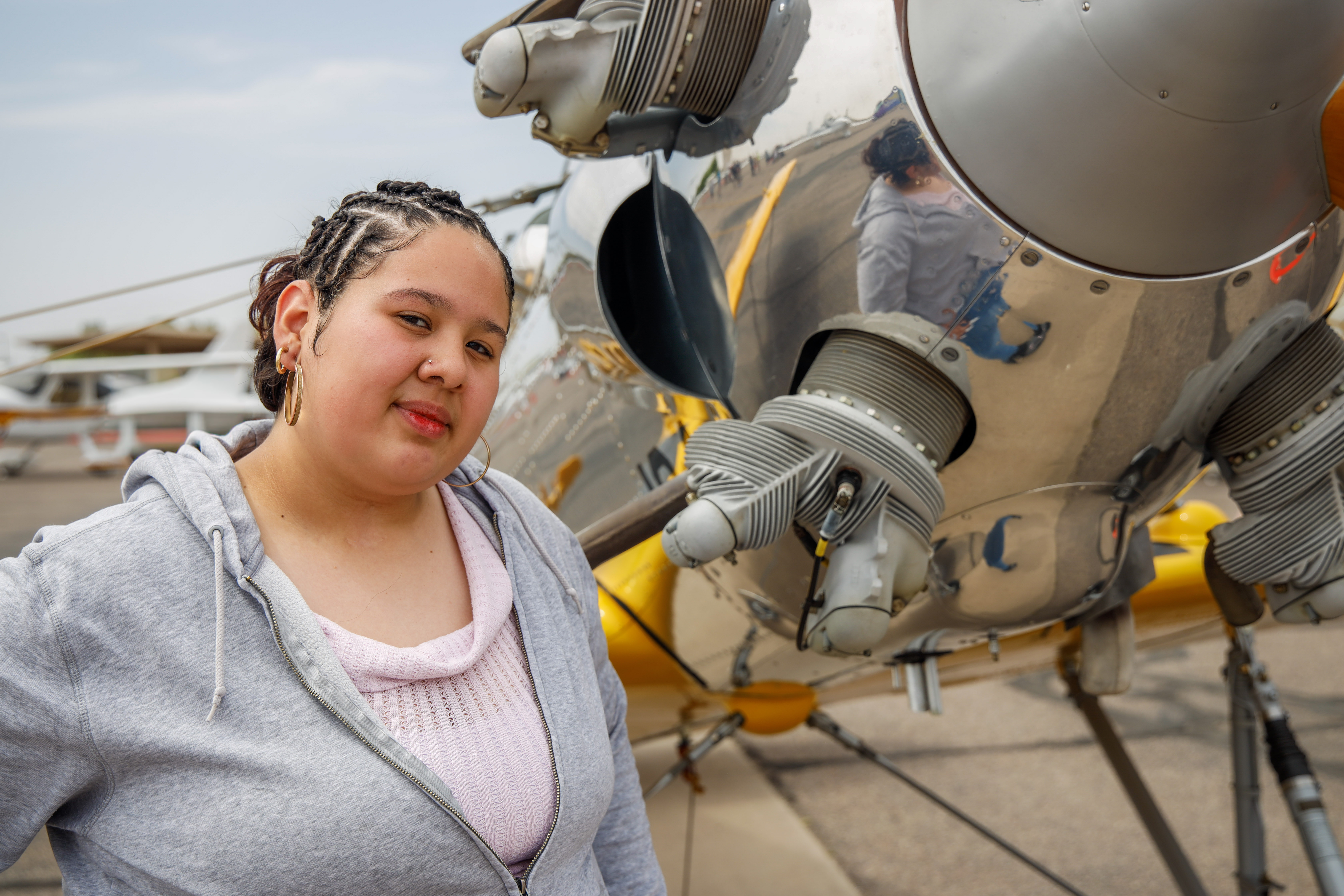 Adriana (Paulina) standing in front of silver plane