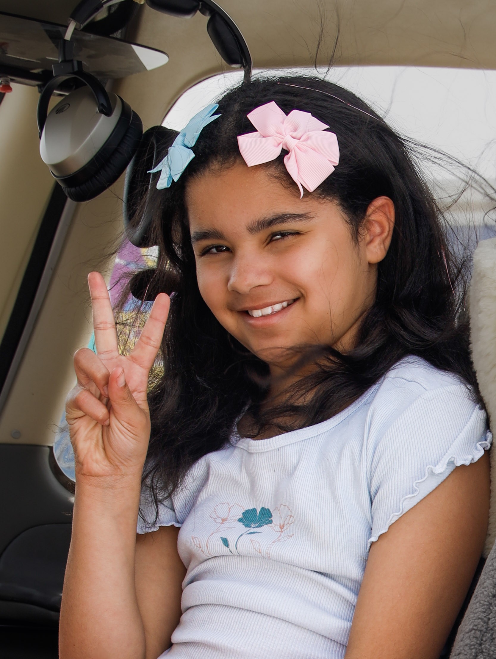 Addy sitting in plane with peace sign