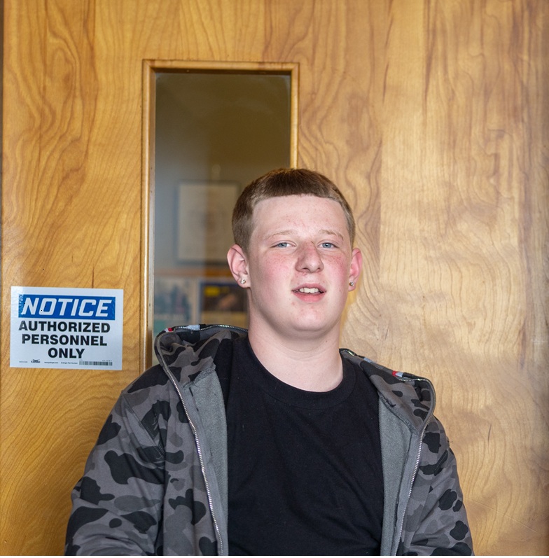Augustine standing by door smiling