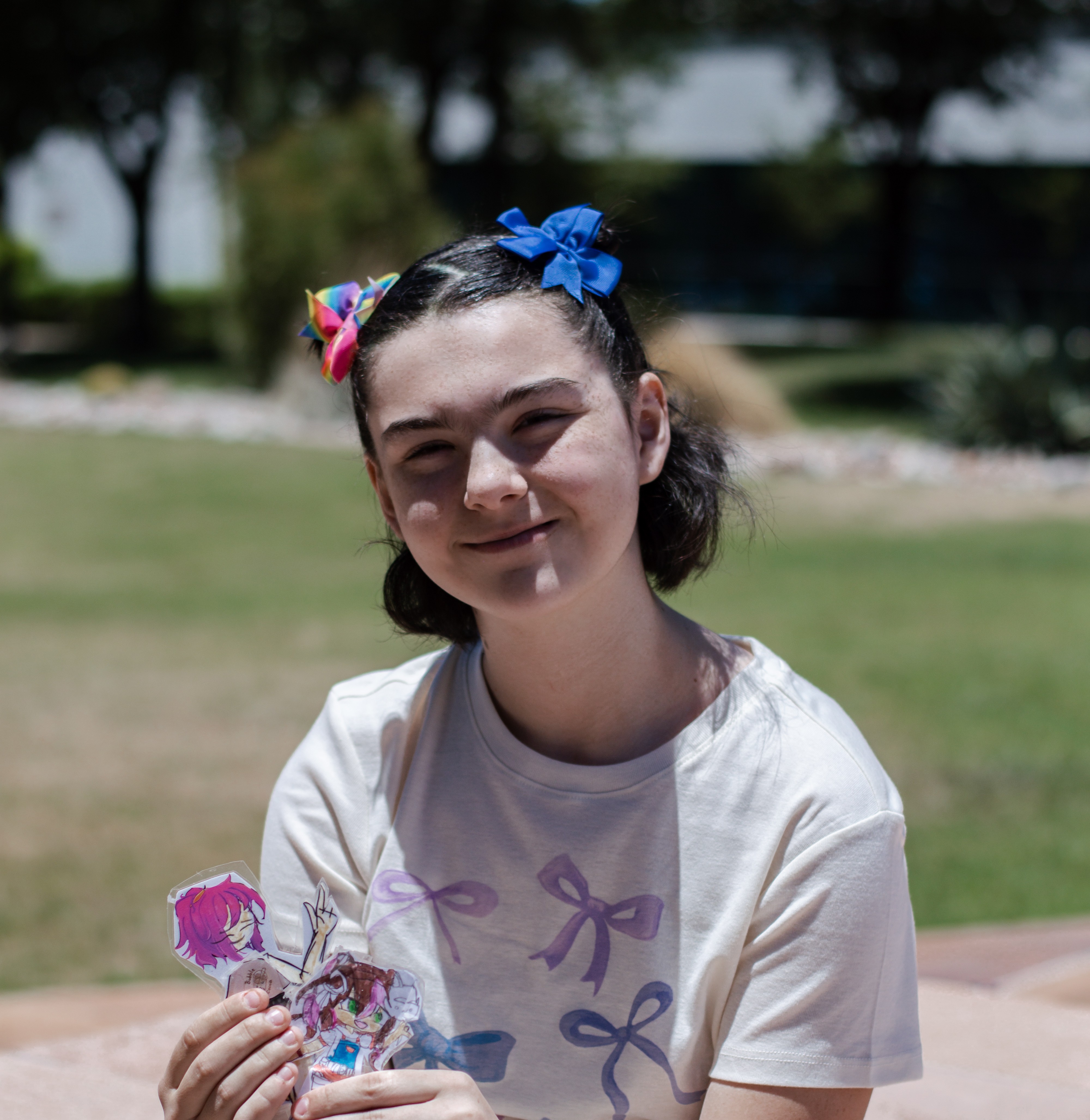 Isabella sitting with grass and trees in background