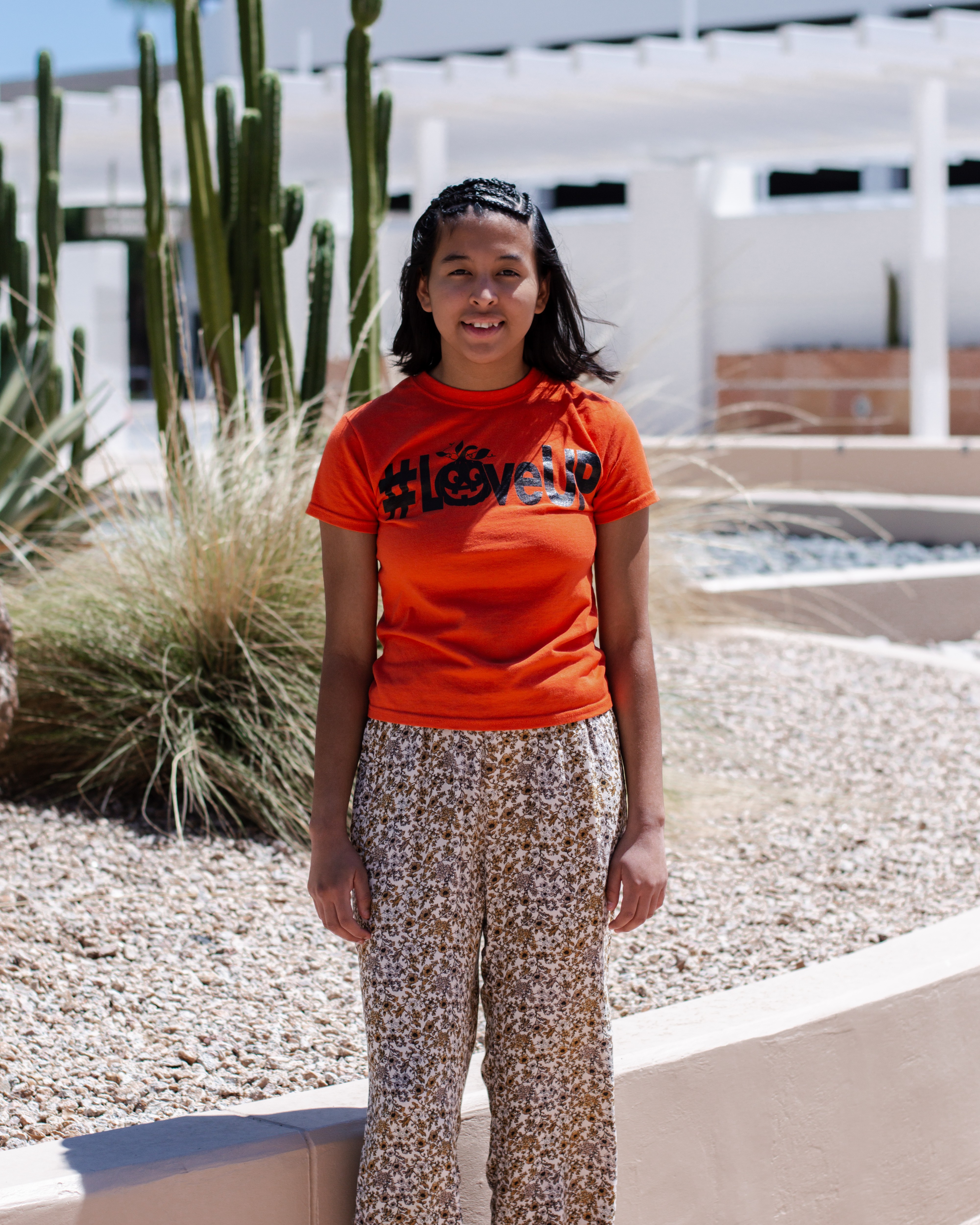 Lizbeth standing with cactus and building in background