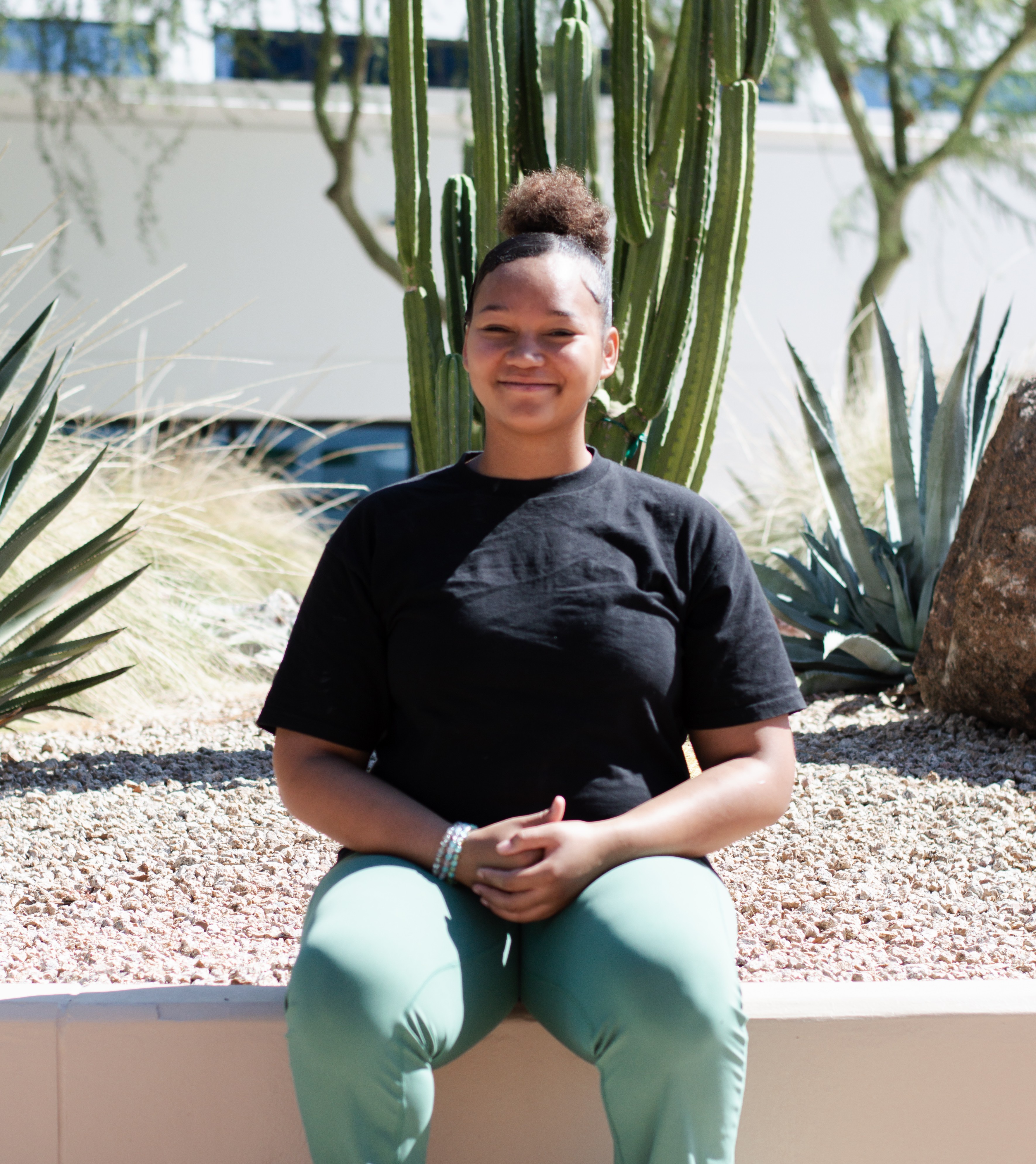 Mersadies sitting smiling with cactus in background