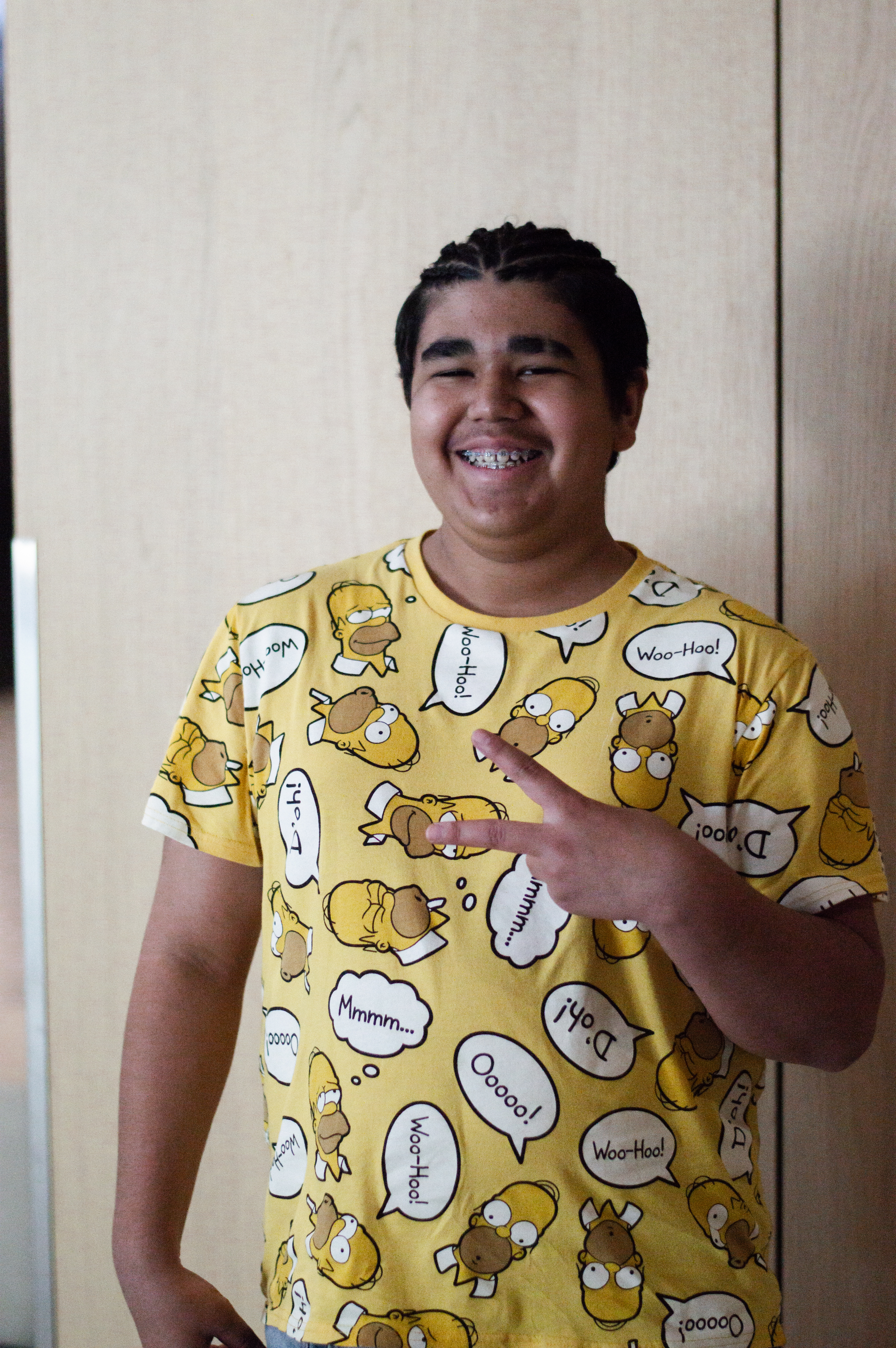 Peter standing with peace sign and smiling