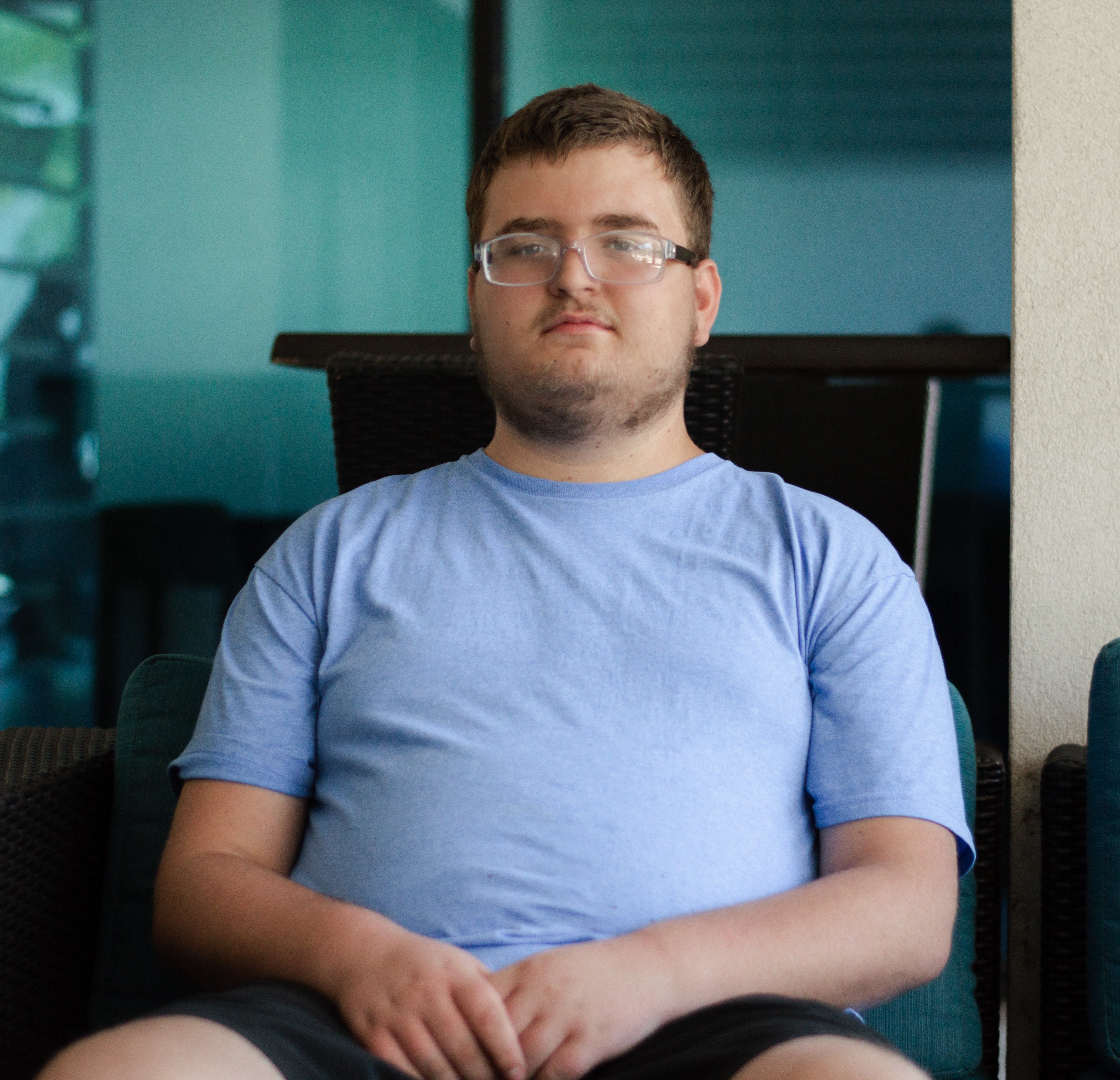 Samuel sitting in chair not smiling