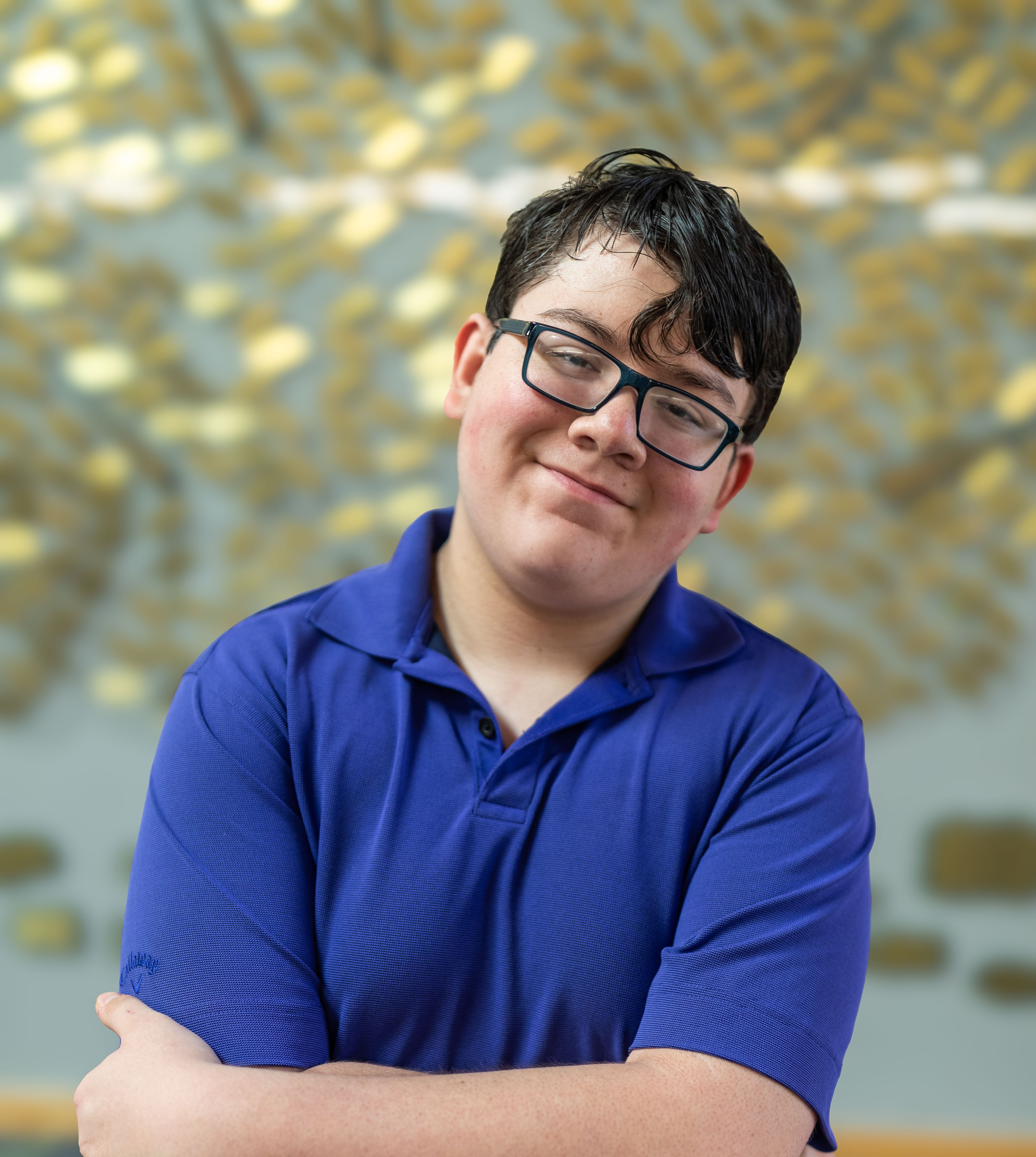 Elijah standing smiling with gold background