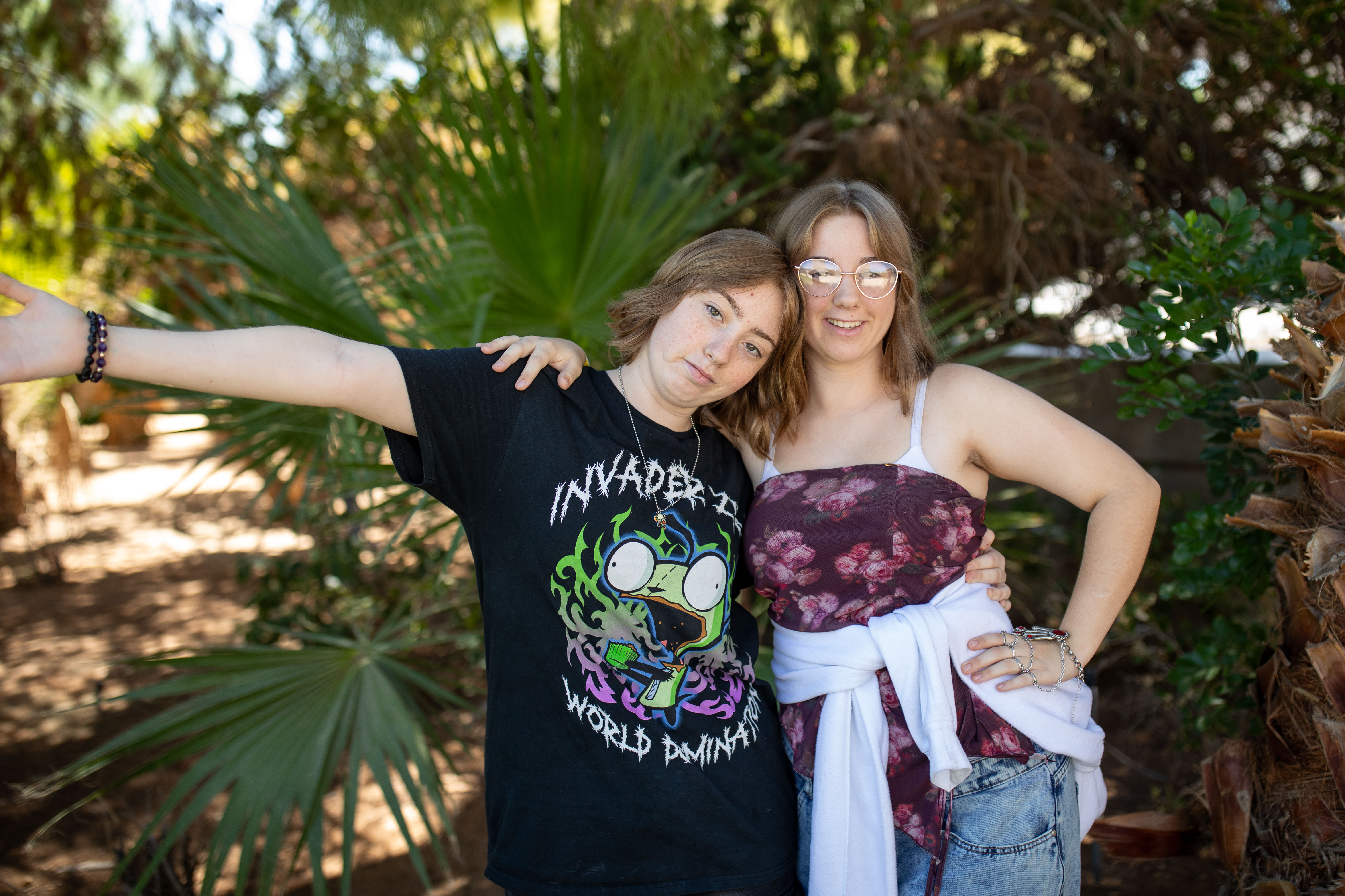 Kari and Sara with her arm out with trees in background