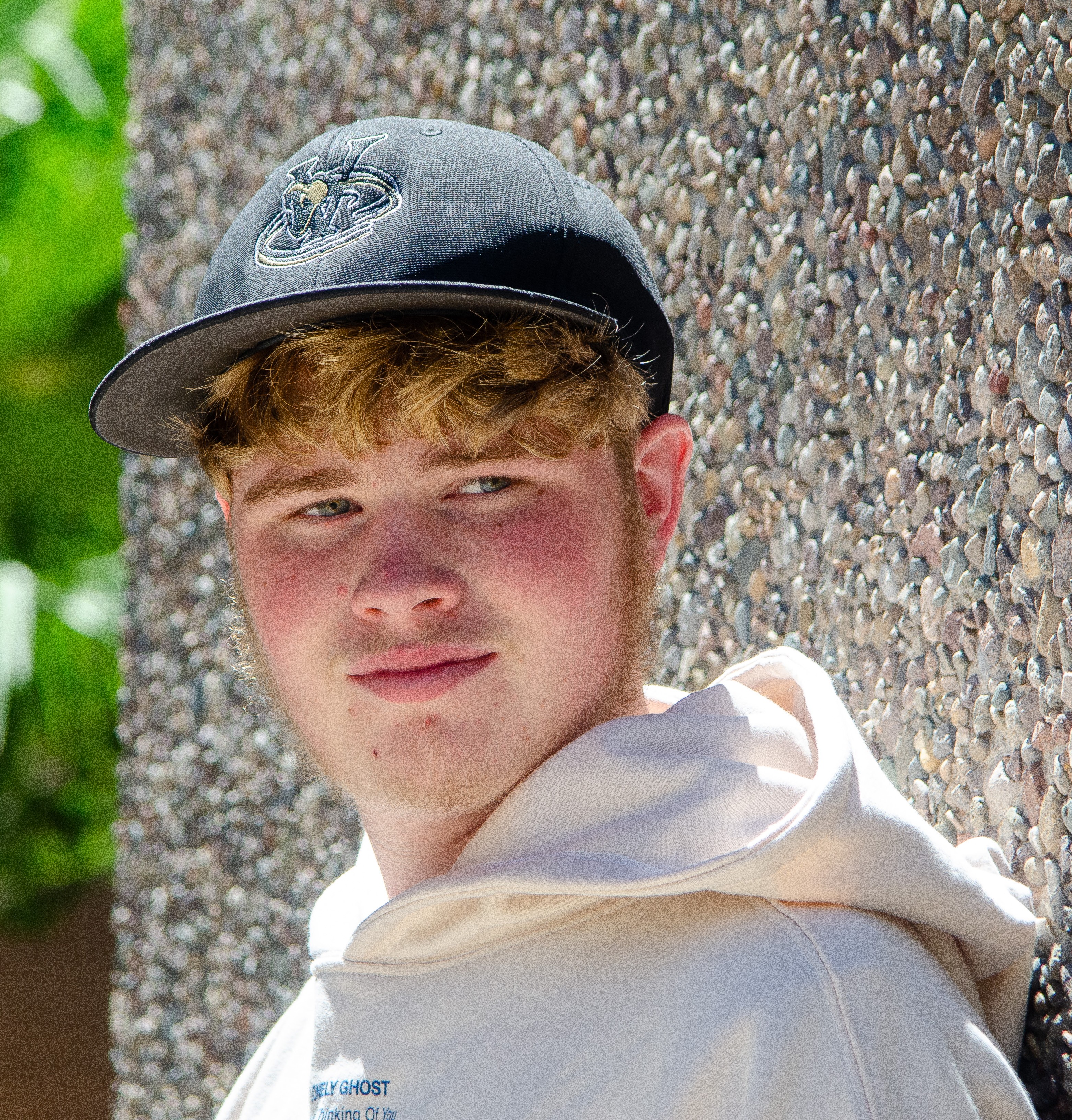 Aaron headshot with rock wall in back