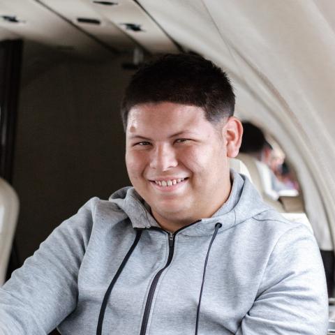 Joshua (2) sitting in plane smiling