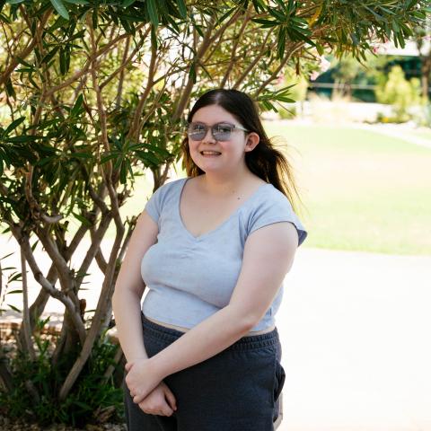 Valerie (2) standing with glasses on by tree