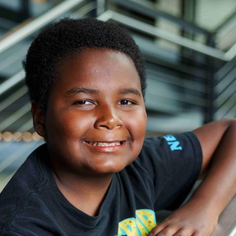 Latrell leaning on stair rail