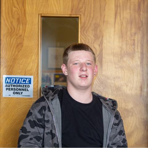 Augustine standing by door smiling