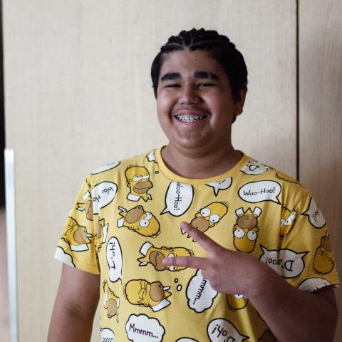 Peter standing with peace sign and smiling
