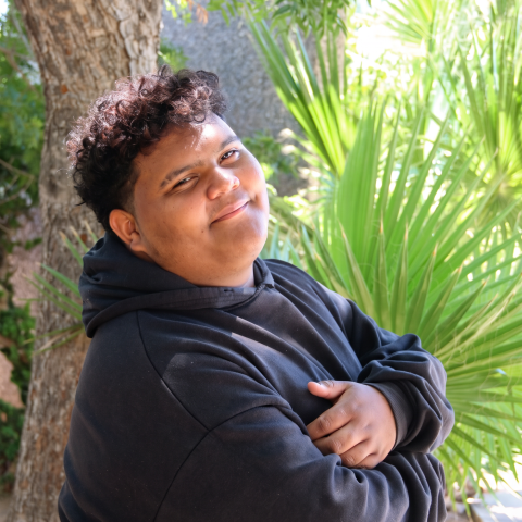 Brayan leaning against a tree