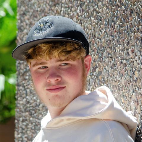 Aaron headshot with rock wall in back